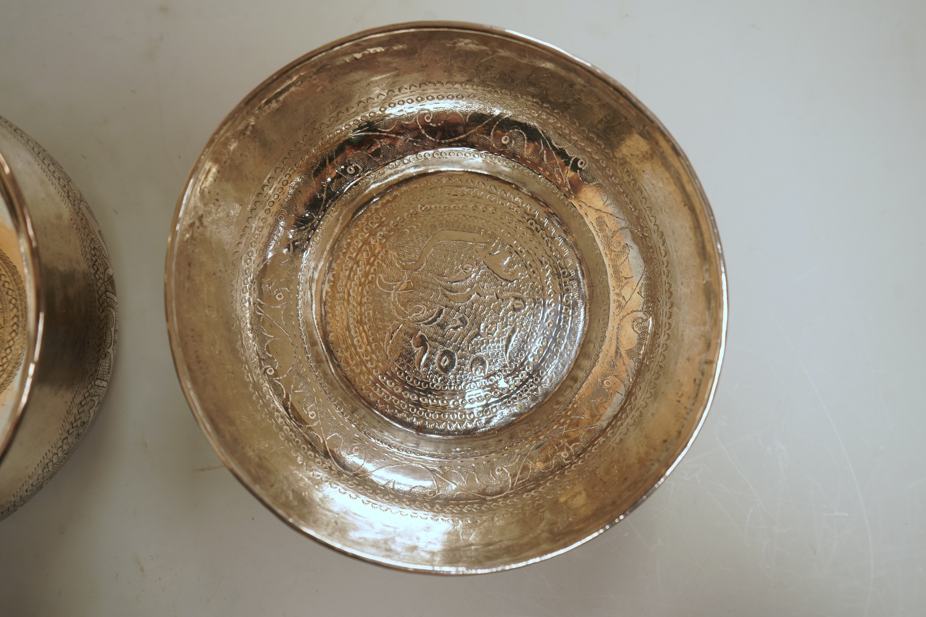 Two early to mid 20th century Persian engraved white metal bowls, both diameters approximately 11.5cm.